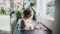 The image shows a baby girl bathing in a kitchen sink.